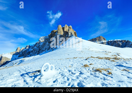 Trauring-Skulptur aus dem Schnee im Winter Berghang (Sellajoch, Italien). Stockfoto