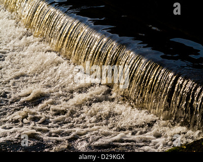 Nahaufnahme des Wassers, das über ein Wehr auf den Derwent in Matlock Bath Derbyshire Peak District England UK Stockfoto