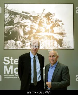 US-amerikanischer Fotograf Steve McCurry (R) posiert mit Museumsdirektor Markus Bruederlin vor seiner übergroßen Foto von Afghanistan Kämpfer aus 1980 während einer Pressekonferenz im Kunstmuseum in Wolfsburg, Deutschland, 17. Januar 2013. Rund 100 Fotografien von McCurry von 1980 bis 2011 erscheint auf dem Display im Kunstmuseum Wolfsburg bis 16. Juni 2013. Foto: Holger Hollemann Stockfoto