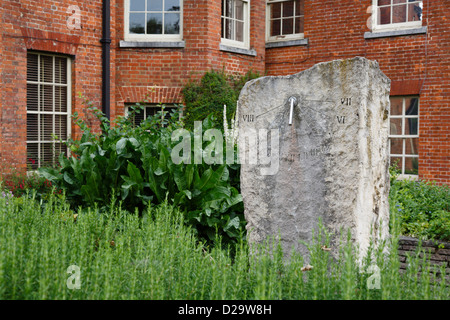 Stone Sonnenuhr im Klostergarten mit Abbey House im Hintergrund. Winchester, Hampshire, UK Stockfoto