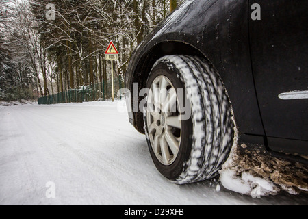 Auto mit Winter Reifen fährt auf einer Straße, komplett mit Schnee bedeckt. Stockfoto