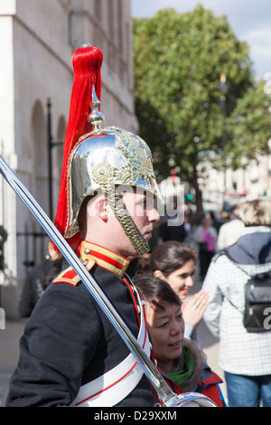 Frau Touristen posiert für ein Foto neben einem Soldaten der "Blues and Royals" Household Cavalry Horseguards Parade. Stockfoto