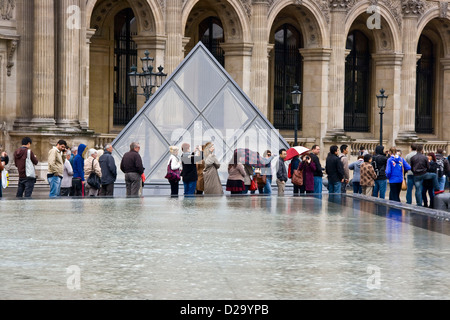 Touristen Warteschlange im Musée du Louvre Innenhof (Cour Napoleon) Paris Ile-de-France Europa Stockfoto