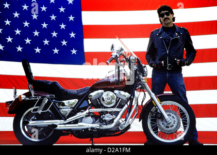 Männliche Motorradfahrer mit Harley Davidson Motorrad und amerikanische Flagge Stockfoto