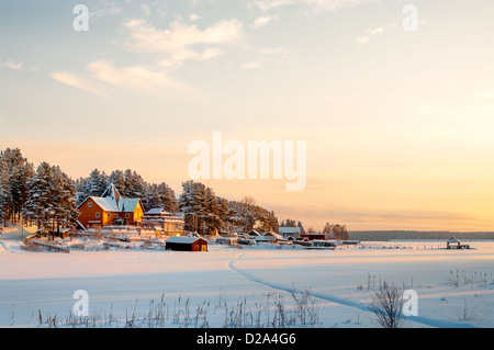 Landhaus am Ufer des Sees im Winter Sonnenuntergang leuchten. Nord-Karelien, Russland Stockfoto