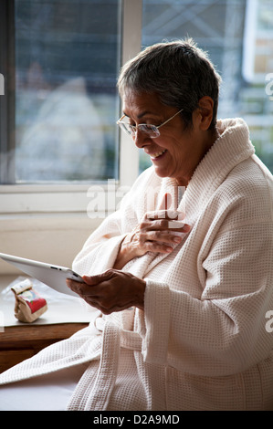 Frau mit Ipad / Tablet am Küchenfenster in Mexiko-Stadt DF Stockfoto