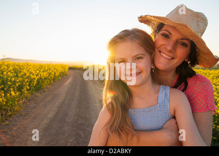 Mutter und Tochter umarmt auf Feldweg Stockfoto