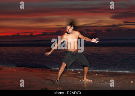 Junger Mann tun Capoeira am Strand bei Sonnenuntergang Stockfoto