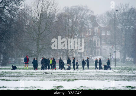 Örtliche Schulen bringen noch ihre Kinder für den Sport auf dem gemeinsamen, obwohl der Schnee. Der Eis-Stall im Cafe ist geschlossen. Schneefall macht pendeln schwieriger aber hört nicht auf Dogwalkers oder Mütter ihre kleinen Kinder auf Clapham Common, London, UK, 18. Januar 2013 herausnehmen. Stockfoto