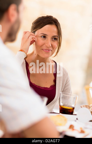 Beim Abendessen lächelnde Frau Stockfoto