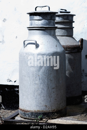 Milchkannen sitzen außerhalb Gebäude Stockfoto