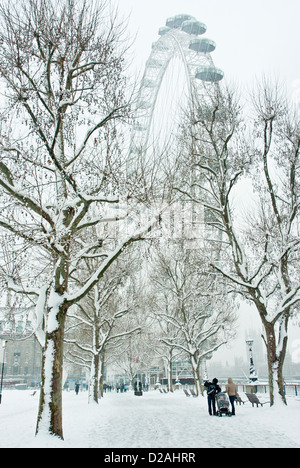 Verschneite Winterlandschaft mit dem London Eye / Rad, Bäume und Pflaster mit Schnee bedeckt. Malerische. Stockfoto