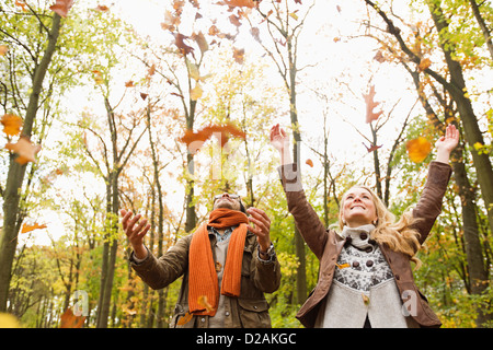 Lächelnde paar spielen im Herbstlaub Stockfoto