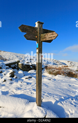 Pennine Way, Top Withens und Bronte fällt hölzerne Wegweiser auf Haworth Moor im Winter Schnee, Haworth, West Yorkshire, England, UK. Stockfoto