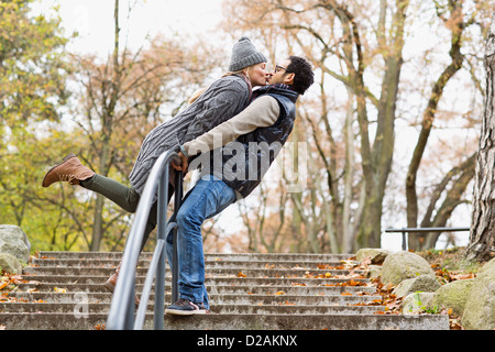 Paar küssen über Park Geländer Stockfoto