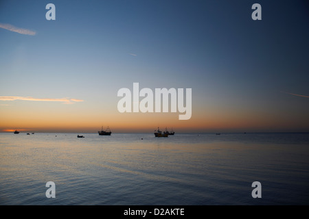 Boote auf ruhigem Wasser bei Sonnenuntergang Stockfoto