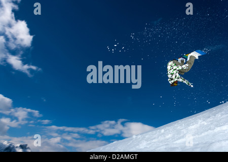 Snowboarder springt auf verschneiten Hang Stockfoto