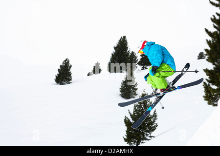 Springen auf verschneiten Hang Skifahrer Stockfoto