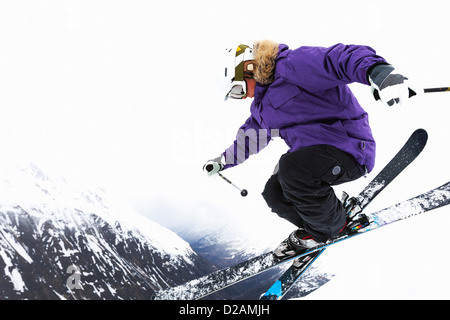 Springen auf verschneiten Hang Skifahrer Stockfoto