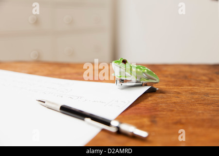 Frosch geformt, Hefter und Stift auf Papier Stockfoto