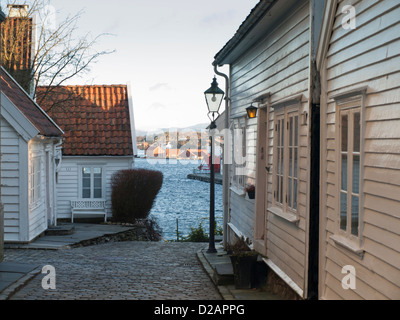 Steile Kopfsteinpflaster und Holzhäuser in der Altstadt von Stavanger Norwegen einen touristische Attraktion und Recidential Bereich. Hafen und Fjord können unten gesehen werden Stockfoto