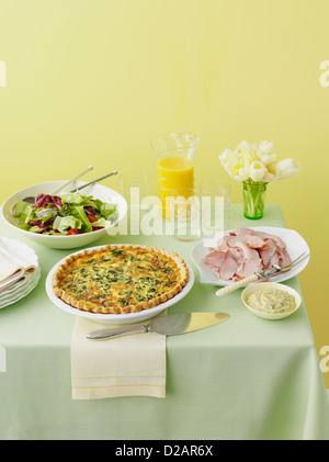 Tabelle mit Quiche, Schinken und Salat Stockfoto