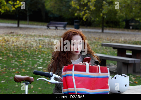 Frau sitzt mit dem Fahrrad im park Stockfoto