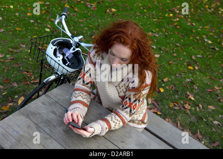 Frau mit Handy an Picknick-Tisch Stockfoto