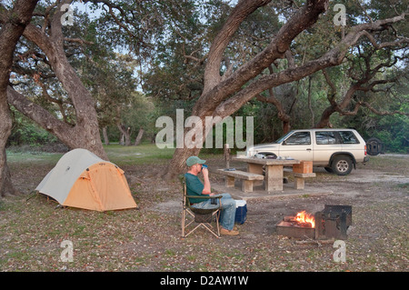 Wohnmobil am Abend Lagerfeuer unter Eichen im Goose Island State Park, Golfküste, Texas, USA Stockfoto