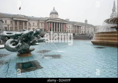 London, UK. 18. Januar 2013. Schnee fällt im Zentrum von London am Freitagmorgen in stumpf Bedingungen am Trafalgar Square mit Eiszapfen bilden auf den Brunnen. Ein Bernstein Unwetterwarnung war für London und der englischen SE angekündigt. CreditL Malcolm Park/Alamy Live-Nachrichten Stockfoto