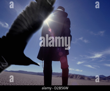 Raven nach einem dunklen menschlichen Figur. Mystische surreale drama Entfaltung auf der Fläche der Wüste. Dunkle Magie der konzeptuellen Kunst Fotografie. Stockfoto