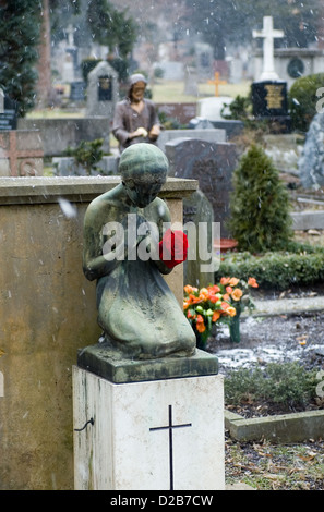 Freiburg, Deutschland, eine trauernde schwere Figur mit rote Rose auf dem Friedhof Stockfoto