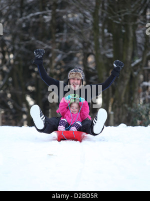 Vater und Tochter Spaß auf frischem Schnee Rodeln Stockfoto