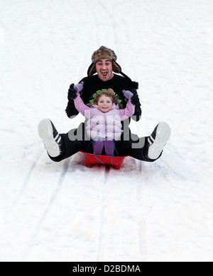 Vater und Tochter Spaß auf frischem Schnee Rodeln Stockfoto