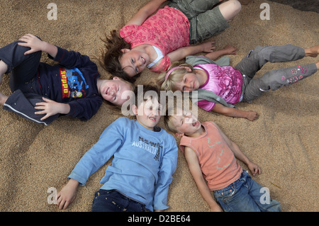 Glänzend, Deutschland, Dorfkinder liegen auf Weizenkoernern Stockfoto