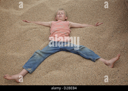 Glänzend, Deutschland, Dorfjunge liegt auf Weizenkoernern Stockfoto