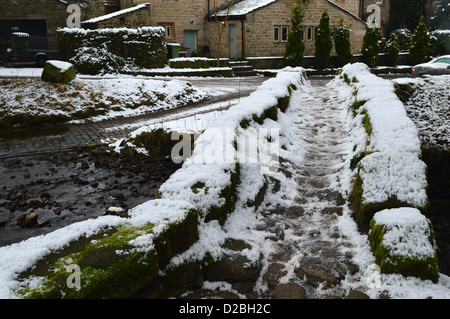 Die gut getragen Nut auf der Lastesel Brücke überspannt Wycoller Beck in der Ortschaft Wycoller in der Nähe von Bronte Weg im Winter Stockfoto