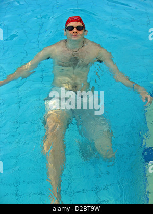 Schwimmer in den Pool mit Wasser mit roten Käppchen Stockfoto