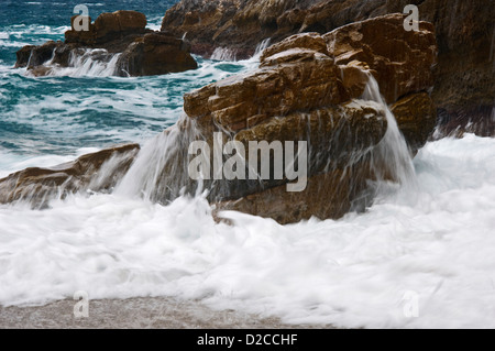 Wellen brechen sich am felsigen Strand Stockfoto