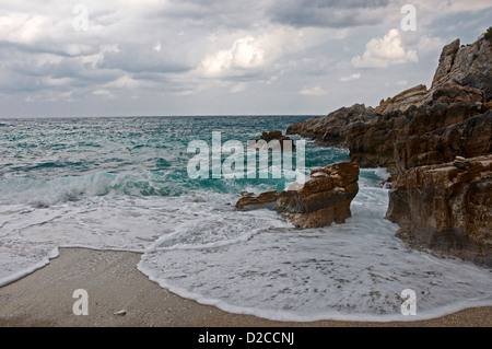 Wellen brechen sich am felsigen Strand Stockfoto