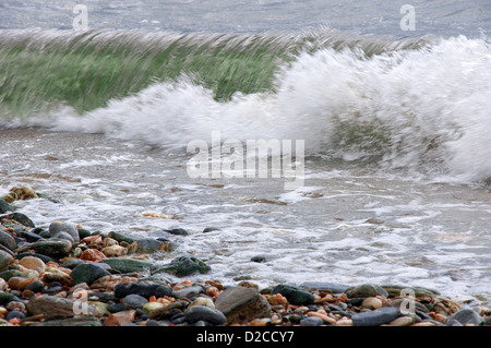 Welle bricht am Kiesstrand Stockfoto