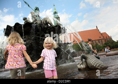 Berlin, Deutschland, kleine Mädchen spielen im Wasser von der Neptun-Brunnen am Alexanderplatz Stockfoto