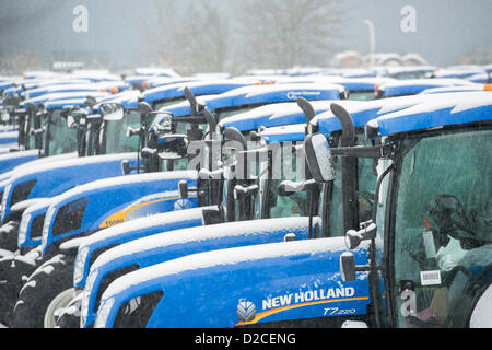 Reihen von Schnee bedeckt, neue Traktoren, bereit für die Lieferung von neuen Holland Traktorenwerk in Basildon, Essex aufgereiht. Stockfoto