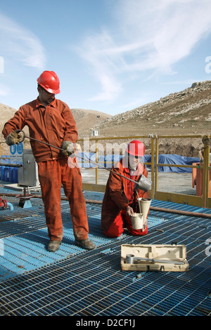 Onshore Öl- und Gas-Exploration-Website. Irakische kurdische Arbeiter die Entnahme von Schlamm aus dem Bohrloch Austritt vor der Anmeldung im Labor Stockfoto