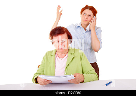 ältere Frau lesen Sie ein Papier und eine junge Frau wie Sie es erklären. Stockfoto