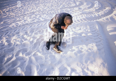 Ein Alter Mann schlafen auf einem Stuhl am Strand von Tel Aviv Israel Stockfoto