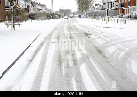 Straße bedeckt im Schnee mit Reifenspuren nach einem Schneefall. Stockfoto