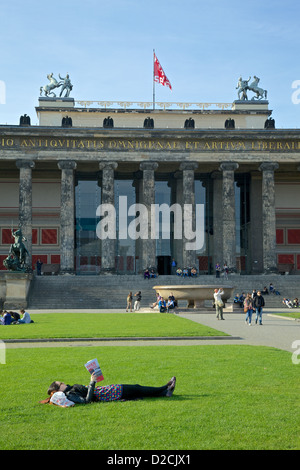 Eine junge Frau entspannt sich und liest in der Lustgarden Berlin, mit dem alten Museum im Hintergrund Stockfoto