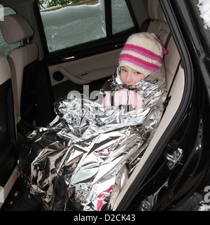 Junges Mädchen in eine Folie Decke Warmhalten in einem Auto