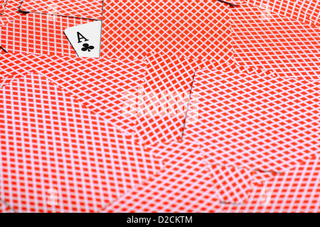 Ein Ass der Vereine Karte ist unter vielen verdeckten Pokerkarten gesehen. Stockfoto